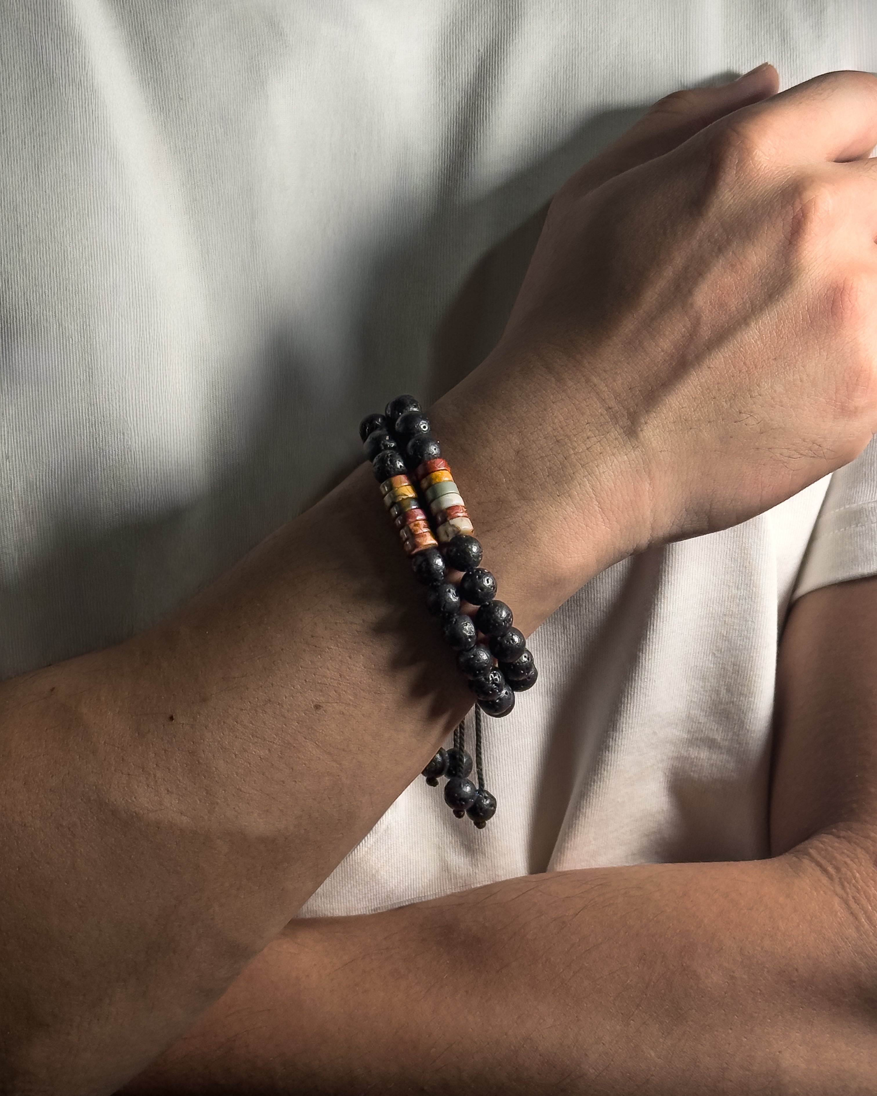 Person wearing The Barrel Bracelet, a handmade adjustable bracelet with 8mm Picasso jasper and lava stone.