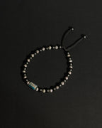 Product image of an adjustable bracelet featuring apatite and matte black onyx against dark background.