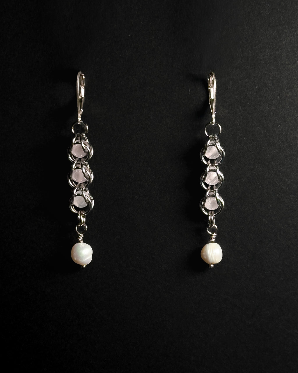 Natural Rose Quartz capture bead earrings with lever back hooks with freshwater pearl against dark background