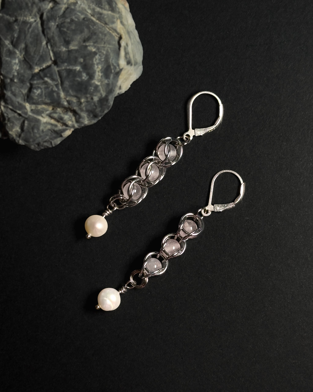 Natural Rose Quartz capture bead earrings with lever back hooks with freshwater pearl against dark background