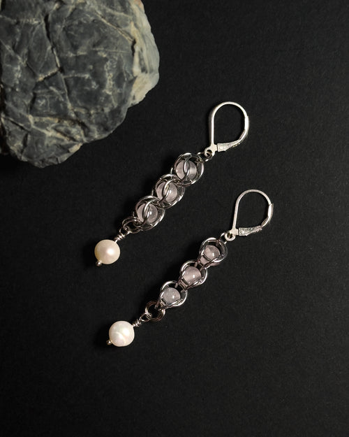Natural Rose Quartz capture bead earrings with lever back hooks with freshwater pearl against dark background