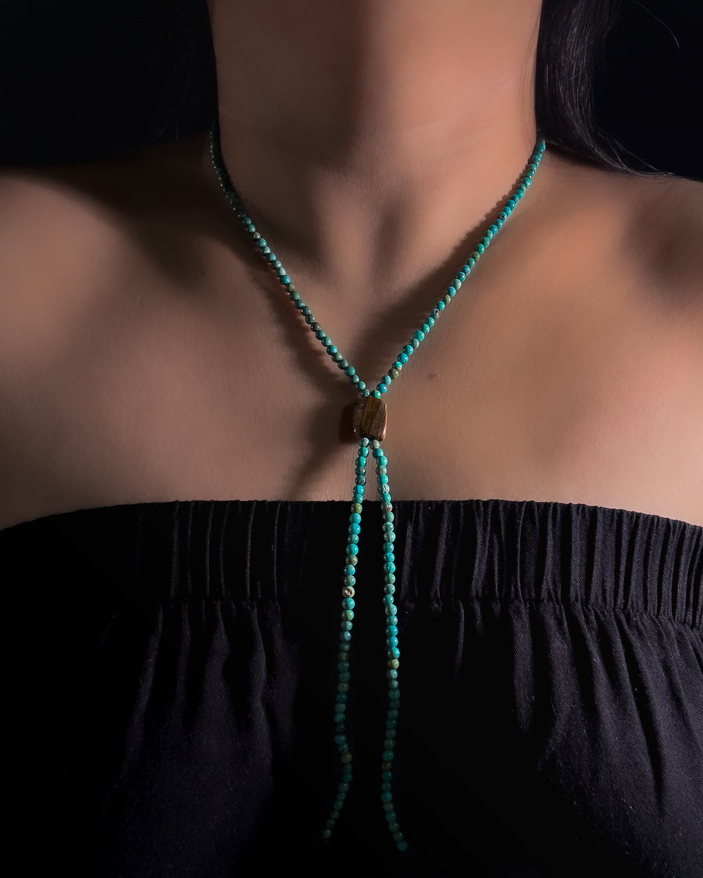 Close-up of natural Tiger Iron centre stone and turquoise beads on a handmade bolo inspired necklace.