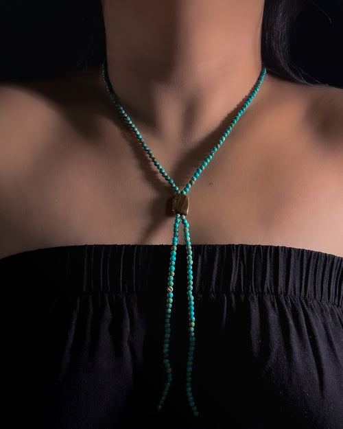 Close-up of natural Tiger Iron centre stone and turquoise beads on a handmade bolo inspired necklace.