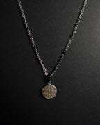 A silver-toned chain necklace with a round textured crushed smokey quartz stone pendant, displayed against a dark black background.