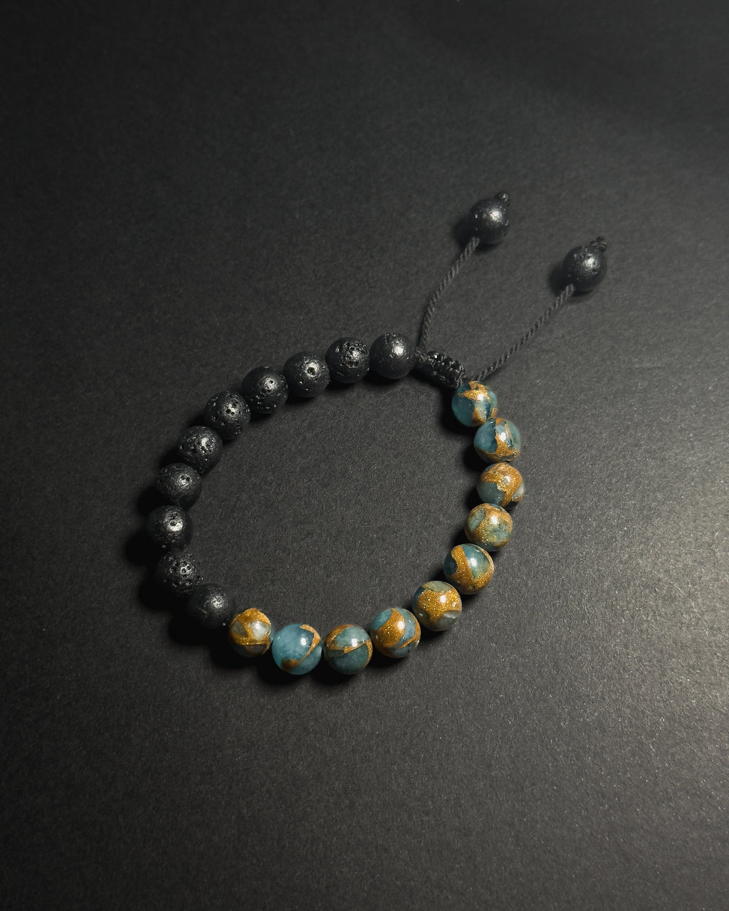 Blue Lake Bracelet featuring 8mm lake blue variscite and lava stone beads with adjustable sliding knot closure.