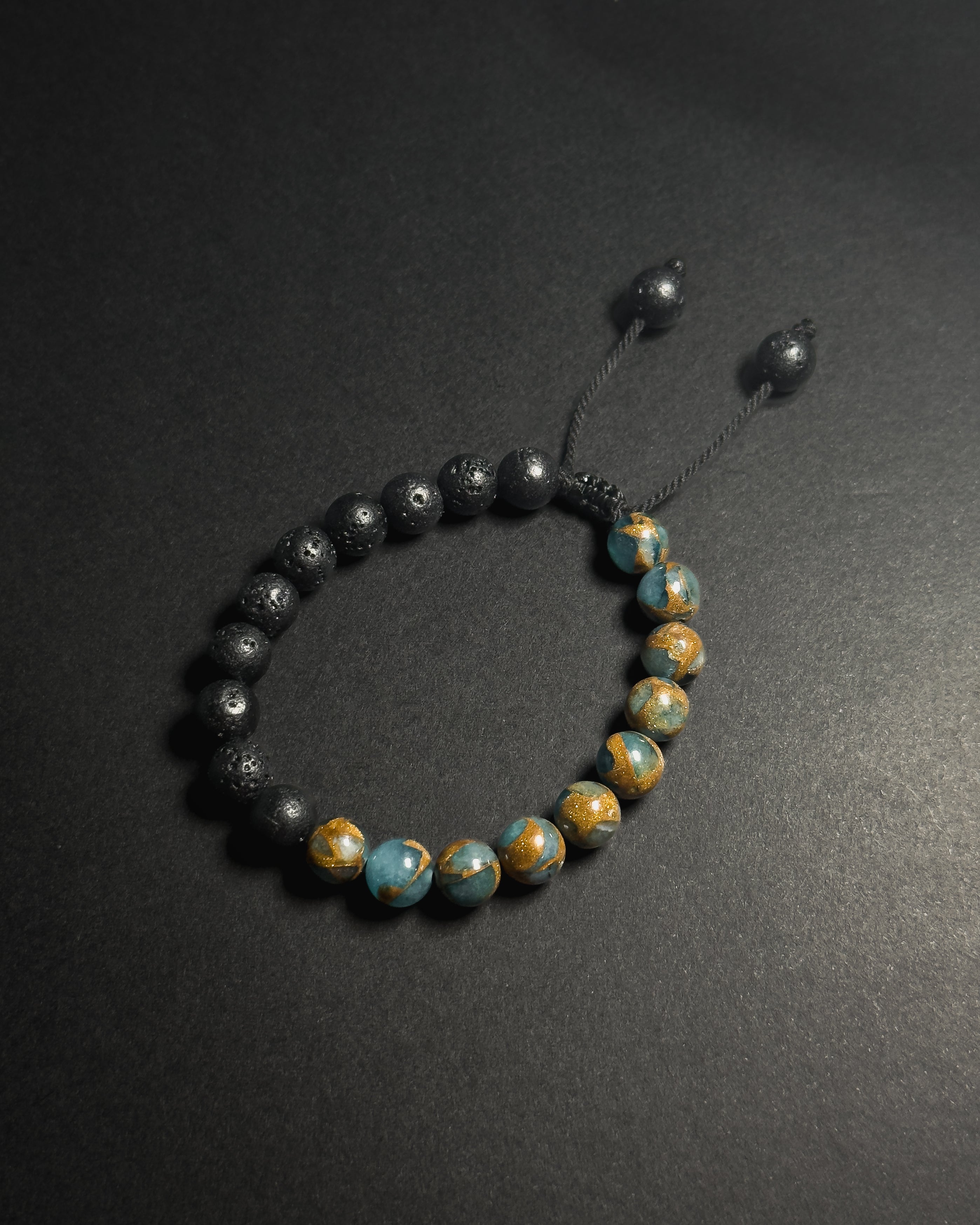 Blue Lake Bracelet featuring 8mm lake blue variscite and lava stone beads with adjustable sliding knot closure.