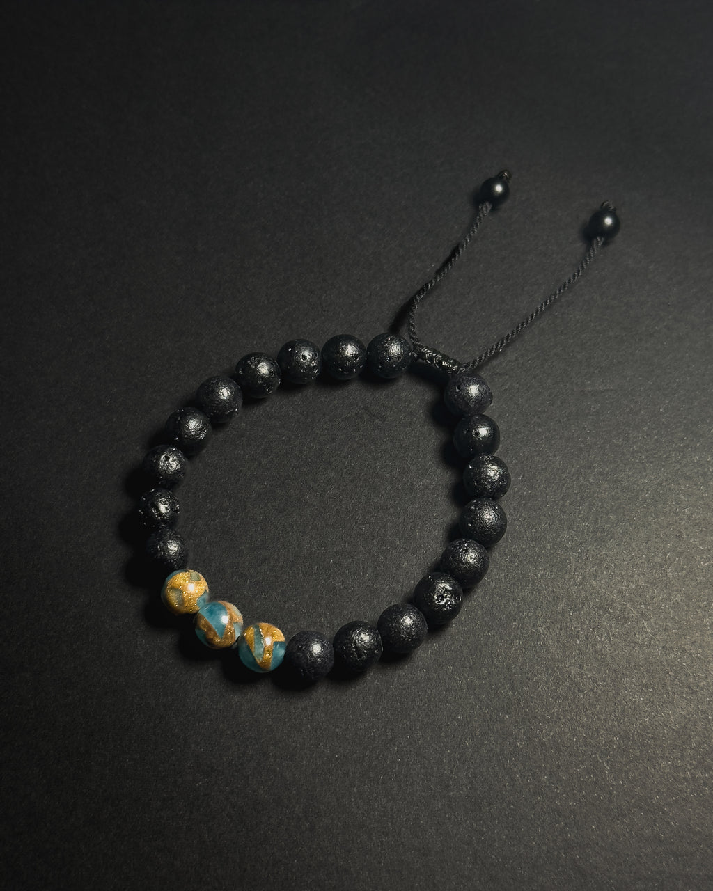 Blue Lake Bracelet featuring 8mm lake blue variscite and lava stone beads with adjustable sliding knot closure.