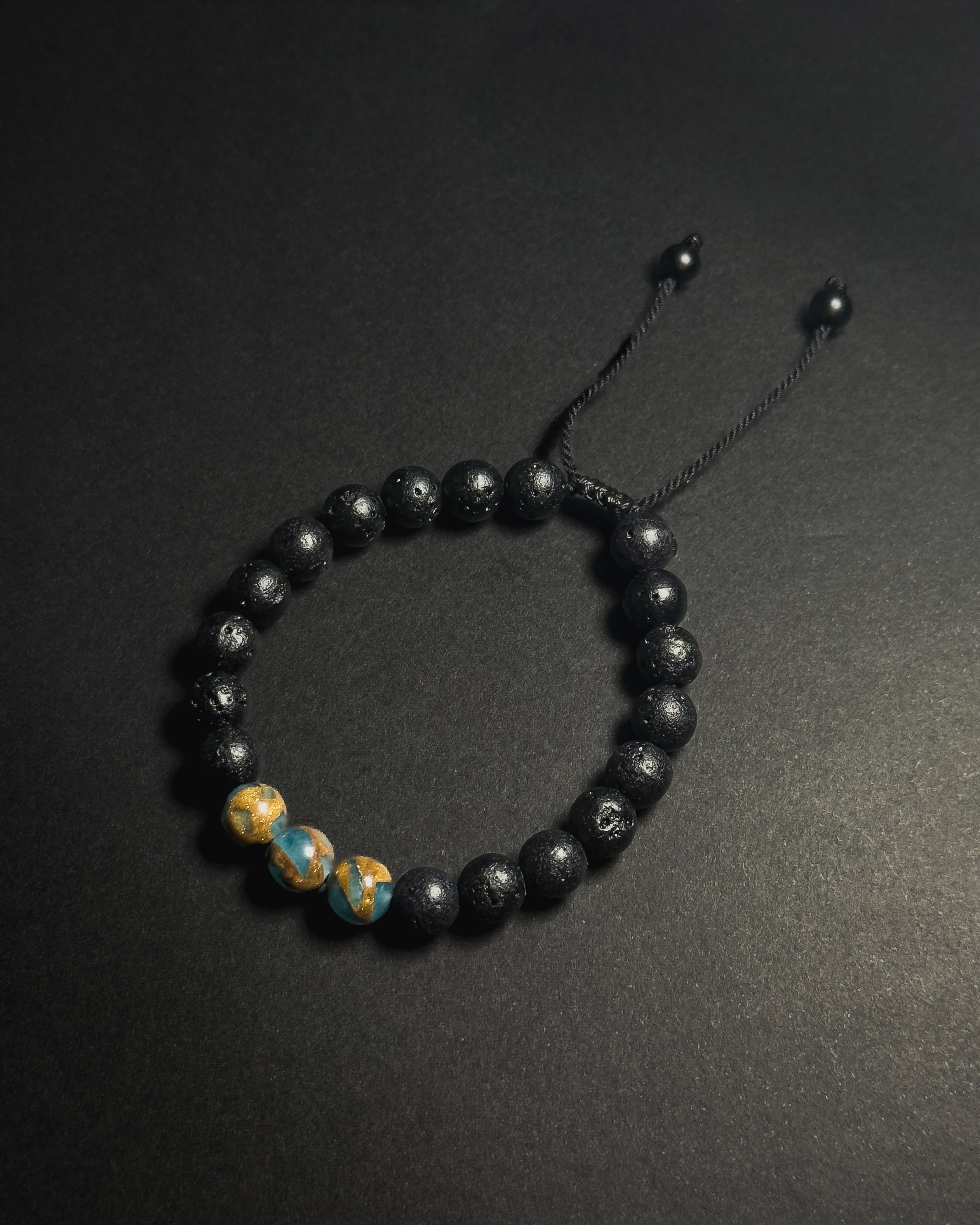 Blue Lake Bracelet featuring 8mm lake blue variscite and lava stone beads with adjustable sliding knot closure.