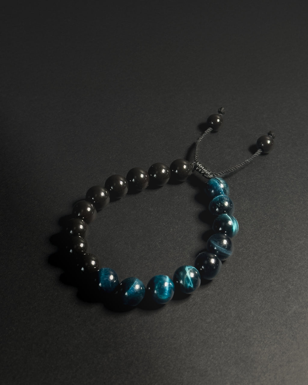 Beaded bracelet with black and blue beads on a dark background