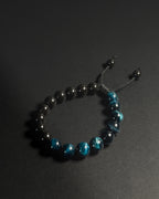 Beaded bracelet with black and blue beads on a dark background