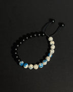 Handmade natural K2 and Matte Black Onyx adjustable bracelet aainst dark background.