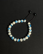 A beaded stretch bracelet made of K2 stone beads, with a dark brown adjustable cord displayed on a dark background.