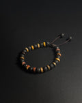 Bracelet with black, orange, and yellow beads on a dark background