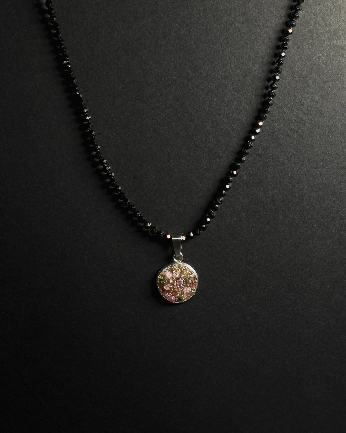 Natural spinel beaded necklace with a stainless steel pendant featuring crushed rainbow tourmaline inlay.