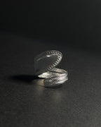 Solid stainless steel spoon ring with a textured, stud-like in a wrap finish, shown open on a dark surface.