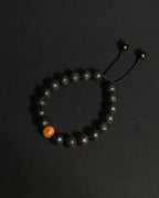 Close-up of natural 10mm sunstone and lava stone beads on The Rising Sun Bracelet showing unique stone textures and variations.