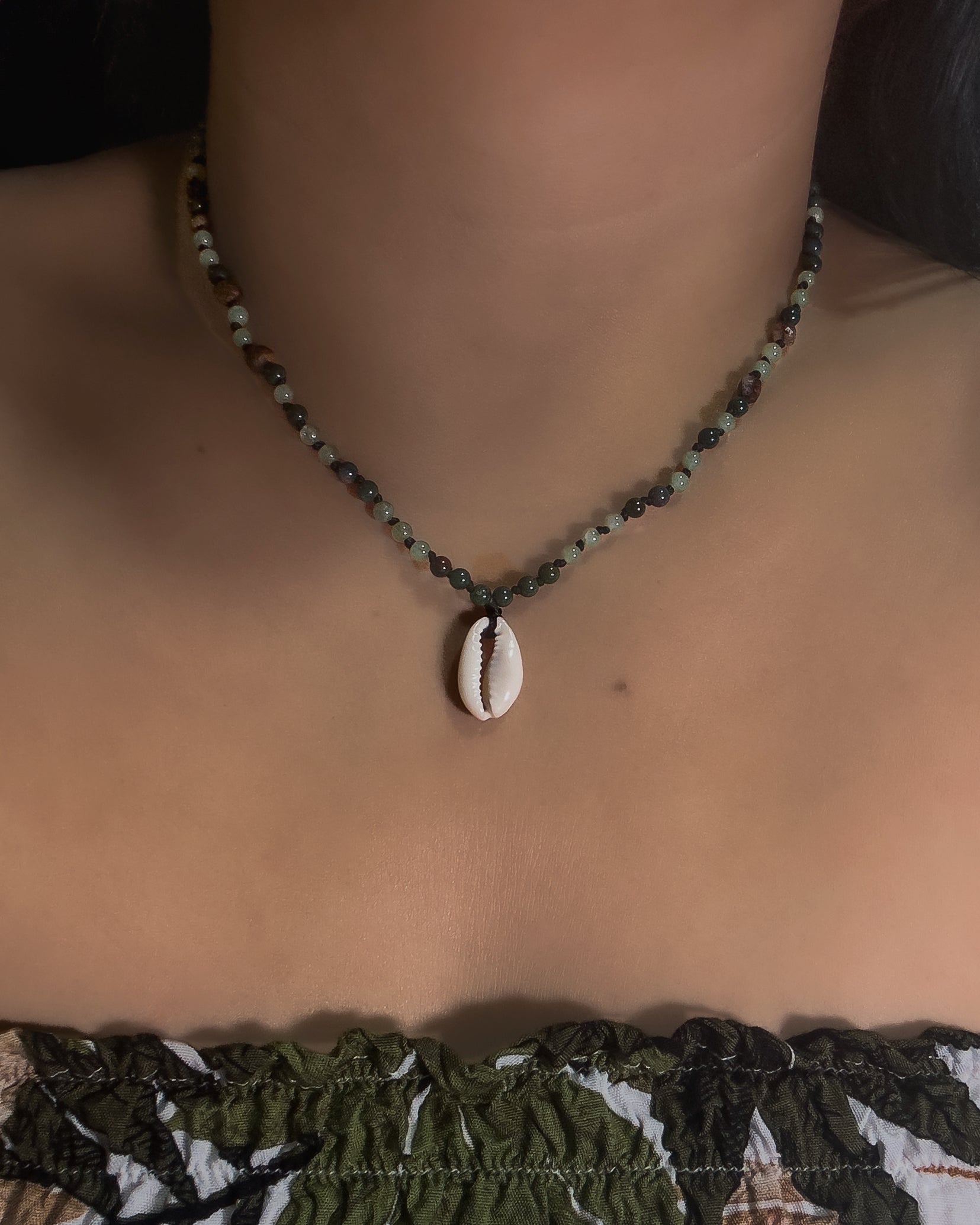 Beaded Necklace with a shell pendant worn by a model